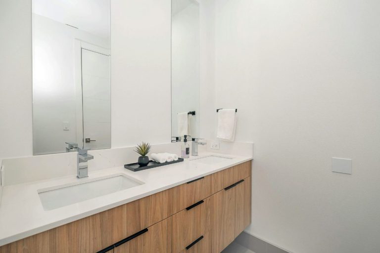 Bancada de banheiro branco com armário de madeira